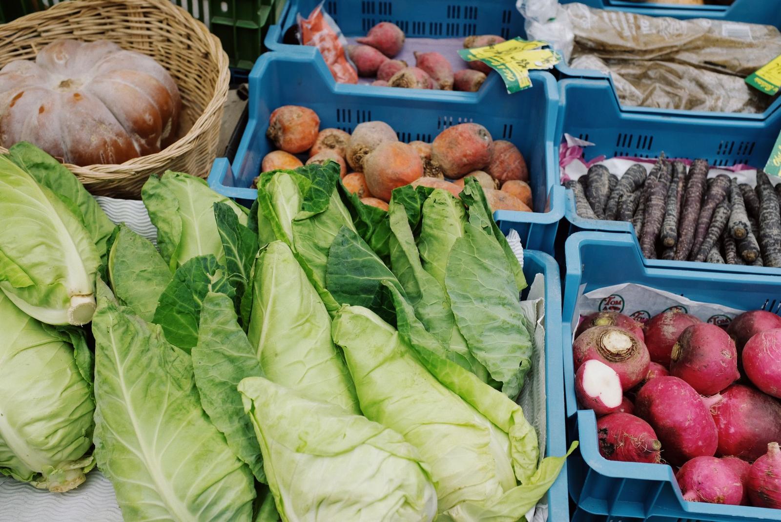 Plastic Containers with Fresh Vegetables on Stall in Market